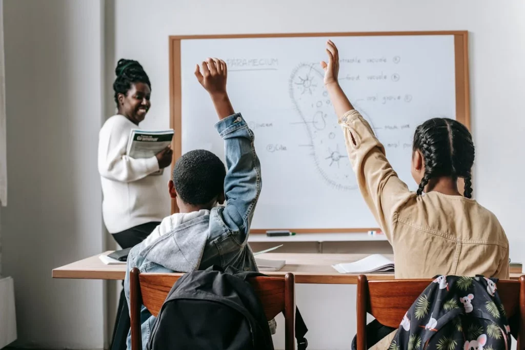 https://www.pexels.com/photo/black-woman-with-pupils-in-classroom-5905557/